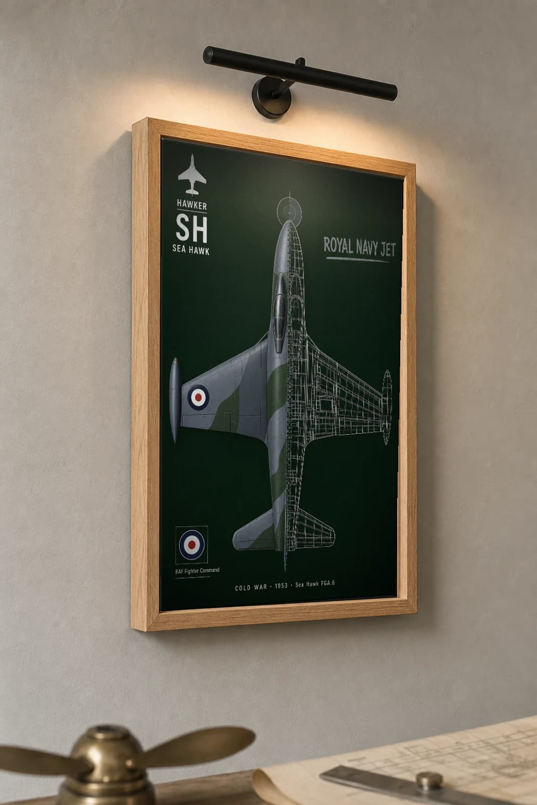 Sea Hawk FGA.6 Cutaway Poster — 1953 Royal Navy Jet Fighter-Bomber Split-View Blueprint Print — the framed print shown at a three-quarter angle on a styled gallery wall in a natural-oak frame
