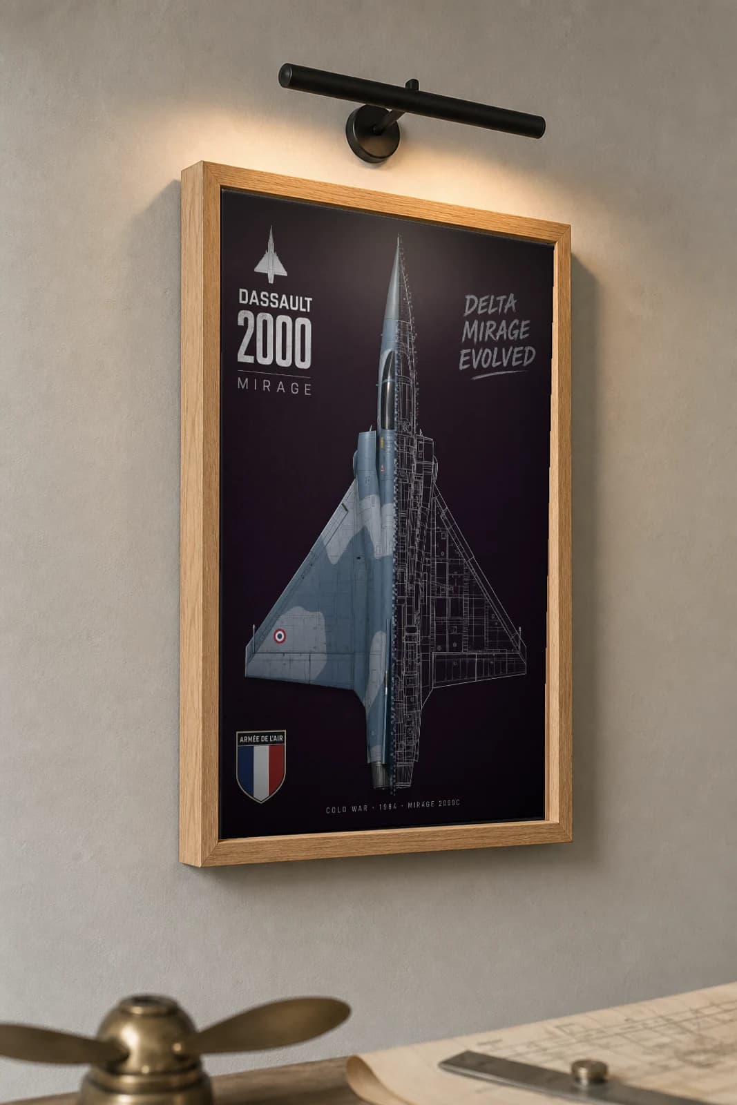 Mirage 2000 Cutaway Poster — Mirage 2000C Cold War Split-View Blueprint Print — the framed print shown at a three-quarter angle on a styled gallery wall in a natural-oak frame