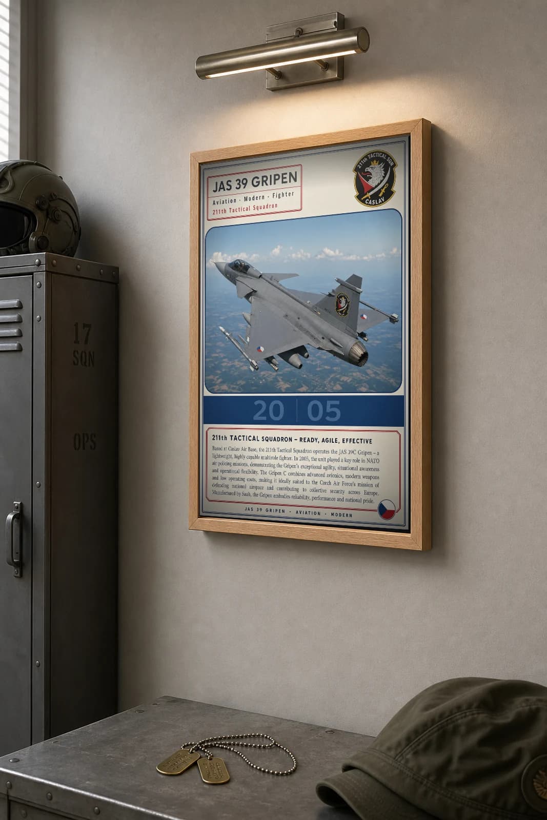 JAS 39 Gripen Poster — 211th Tactical Squadron military aviation wall art · framed A2 · 2005 — the framed print shown at a three-quarter angle on a styled gallery wall in a natural-oak frame