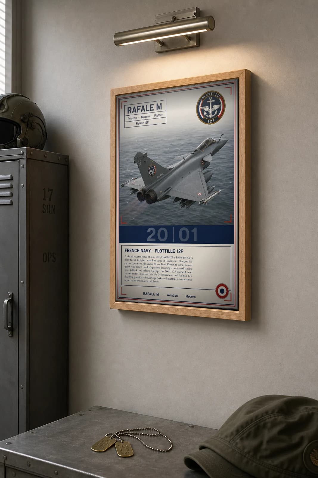 Rafale M Poster — Flottille 12F military aviation wall art · framed A2 · 2001 — the framed print shown at a three-quarter angle on a styled gallery wall in a natural-oak frame