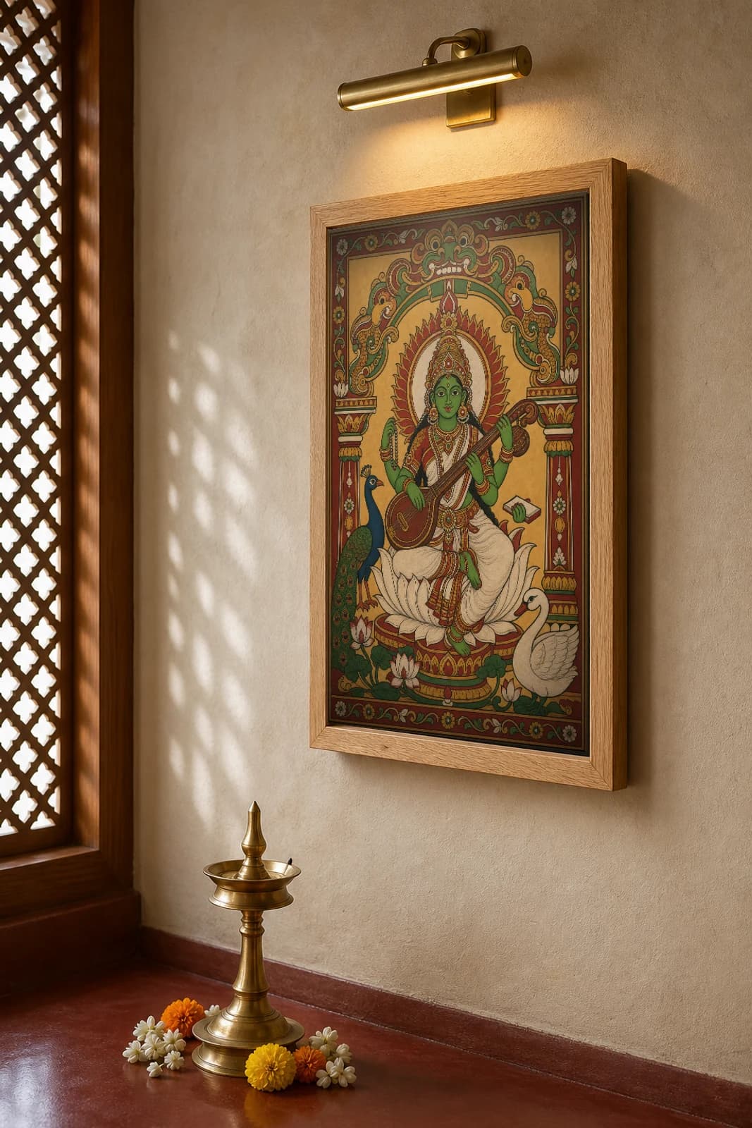 Saraswati with Veena Kerala Mural Art Print — the goddess of learning on a lotus with veena, peacock and swan in panchavarna bhitti-chitra style · collector edition A2 — the framed print shown at a three-quarter angle on a styled gallery wall in a natural-oak frame