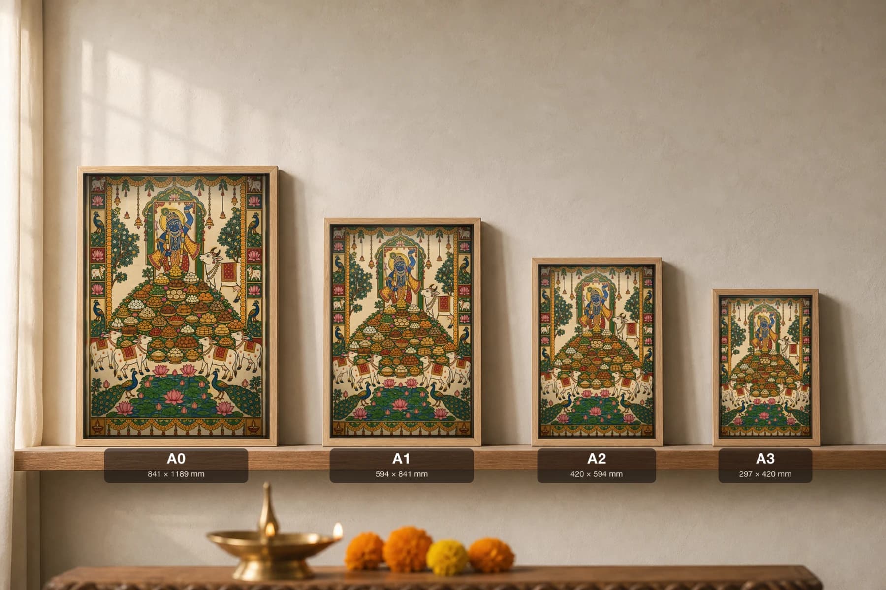 Annakut Feast Mountain Pichwai-Style Print — Shrinathji above a pyramid of food bowls with cows, peacocks and a lotus pond, on warm cream cloth — print size guide showing the artwork at A0, A1, A2 and A3 in natural-oak frames at true relative scale