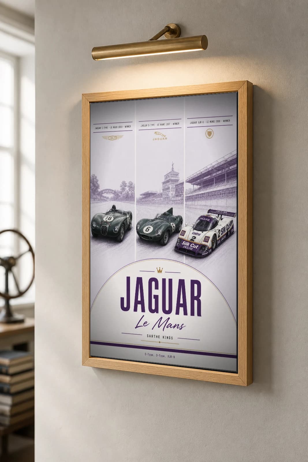 Jaguar factory / works entries C-Type / D-Type / XJR-9 Poster —  Le Mans-winning sportscars WEC racing wall art · #18 / 6 / 2 · framed A2 — the framed print shown at a three-quarter angle on a styled gallery wall in a natural-oak frame
