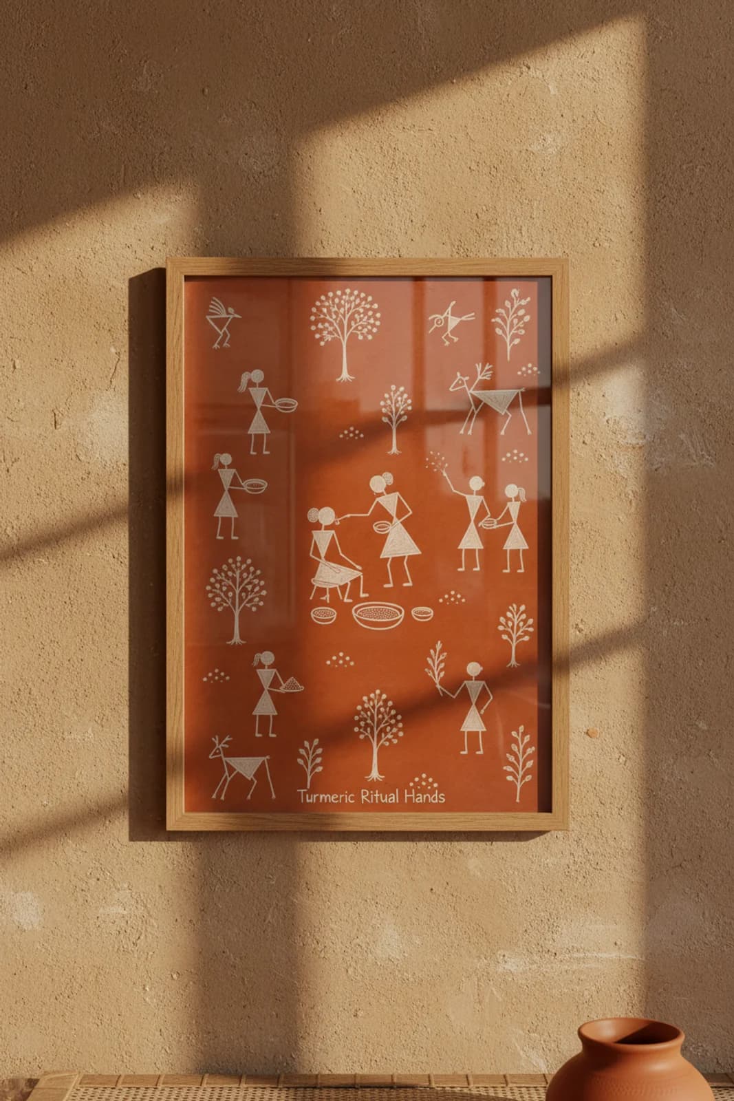 Turmeric Ritual Hands Warli print in natural oak A2 frame on warm-earth-neutral mud-plaster wall — rustic Indian folk art mockup